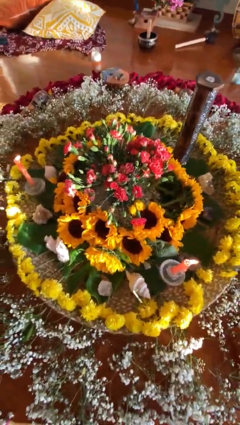 Altar ceremonial con girasoles, claveles y velas dispuestos en mandala
