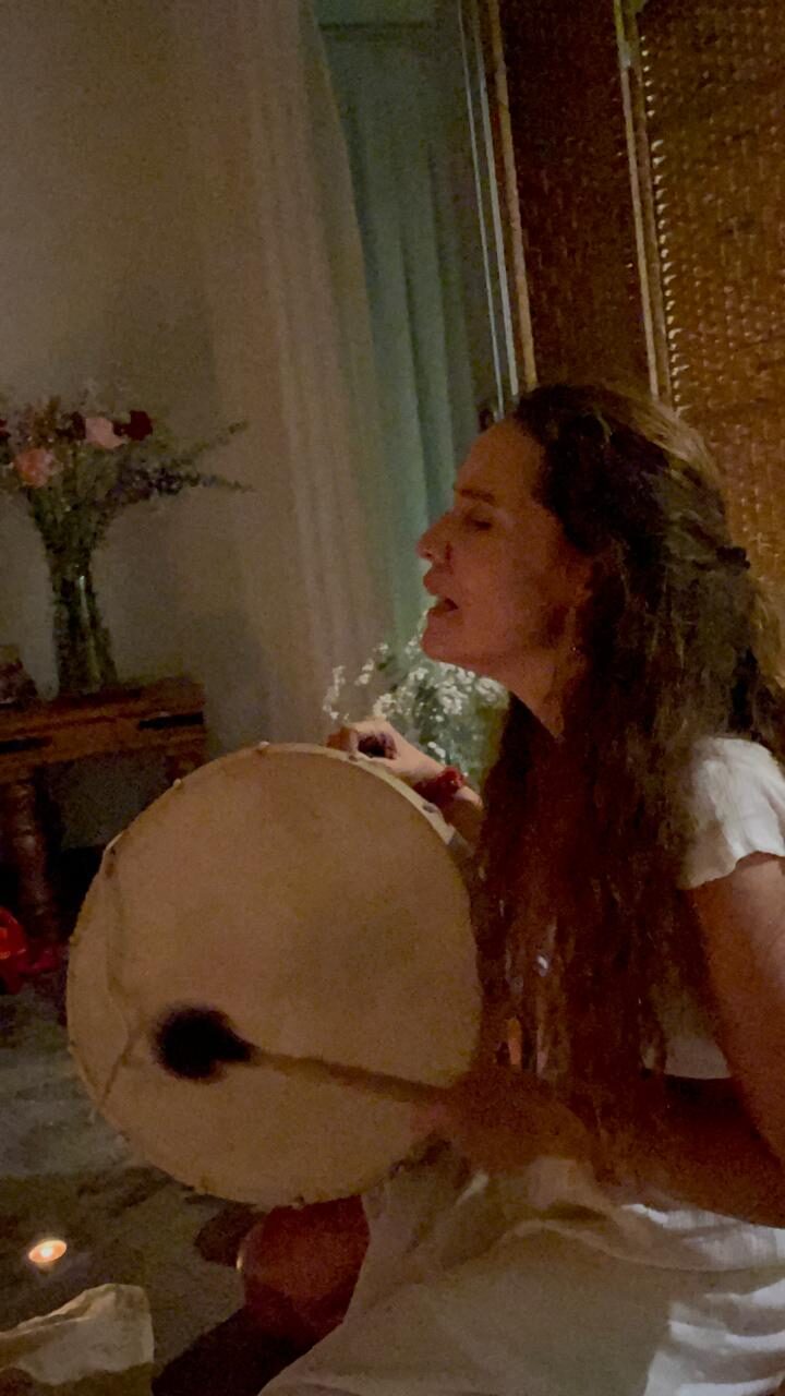 Tania Reyes Acha cantando con el tambor durante una ceremonia